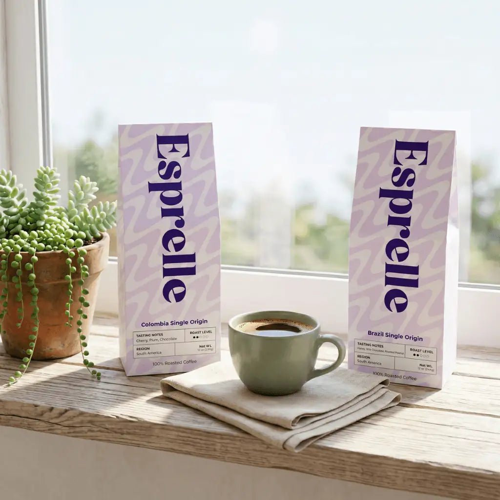 Two Esprelle coffee packages on a wooden surface with a cup of coffee and a plant in the background.