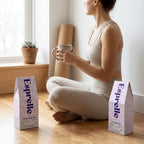 Woman sitting on the floor holding a mug with two Esprelle coffee bags beside her.
